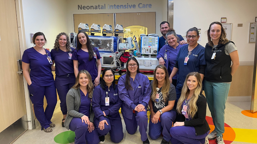 The NICU Transport team at Renown Health pose for a photo in front of a neonatal life support machine.