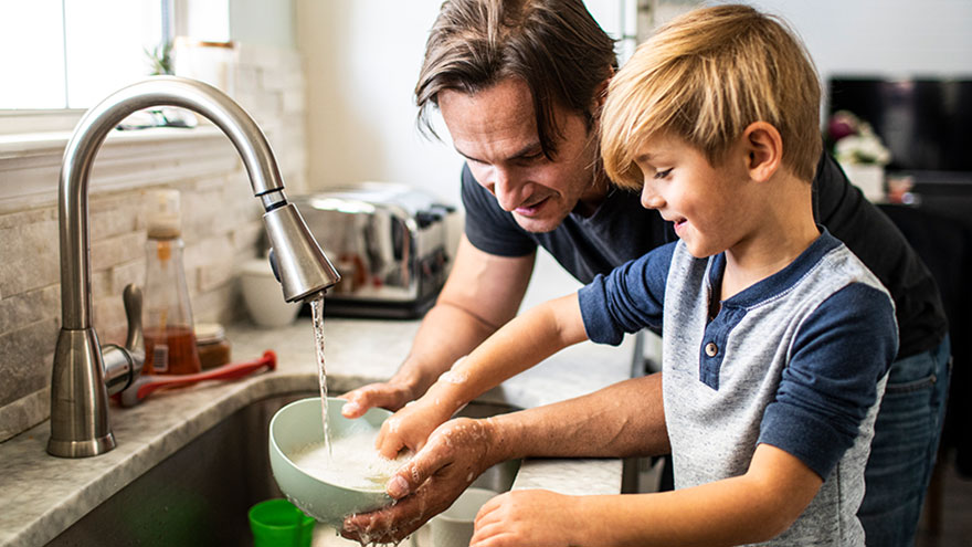 Dad helping son with dishes