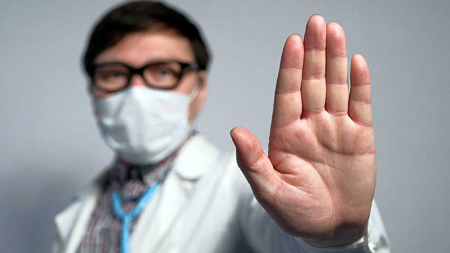 Hospital worker putting hand up to indicate no violence