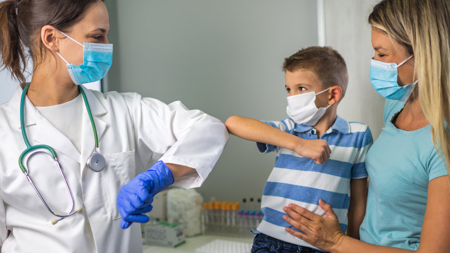 Doctor and little boy patient elbow bumping prior to flu shot