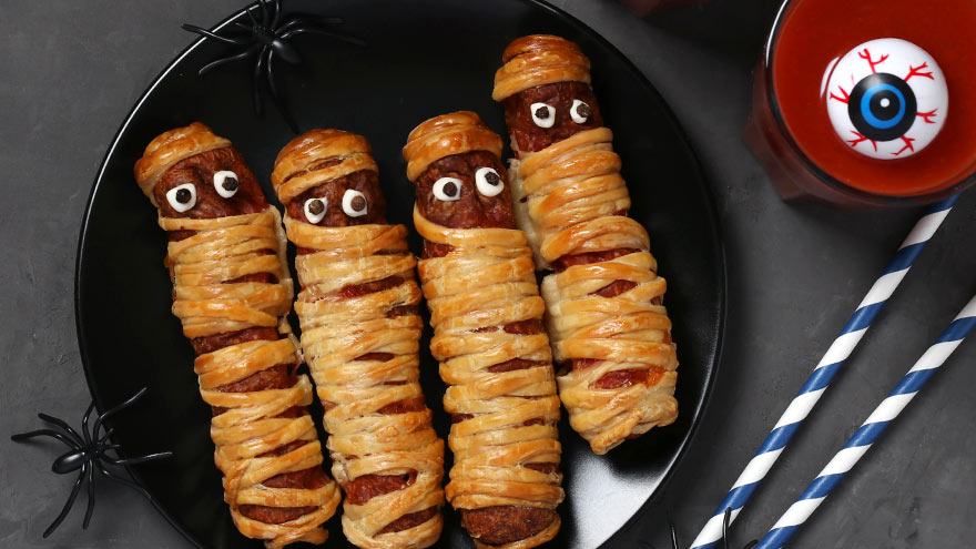 Spooky sausage mummies and tomato juice for Halloween party