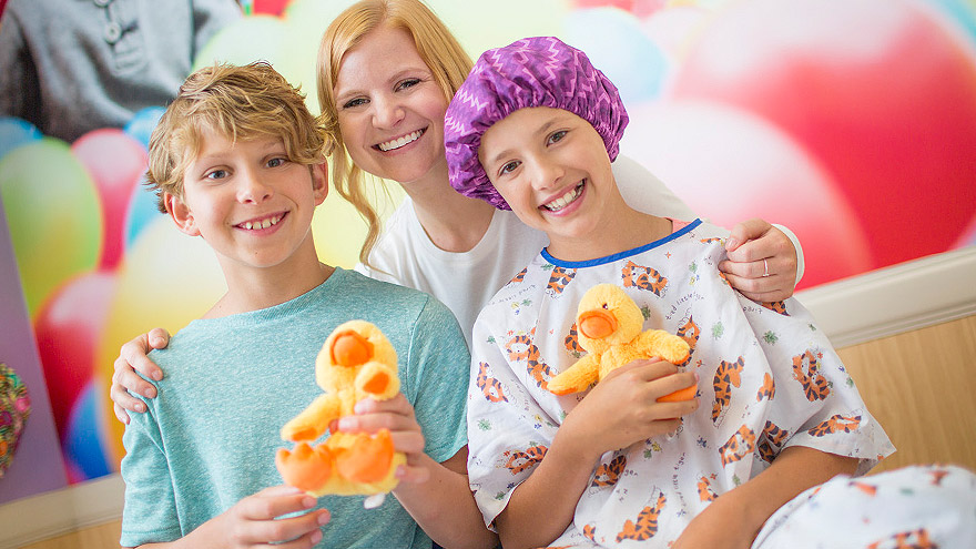 A family smiling and holding toy ducks