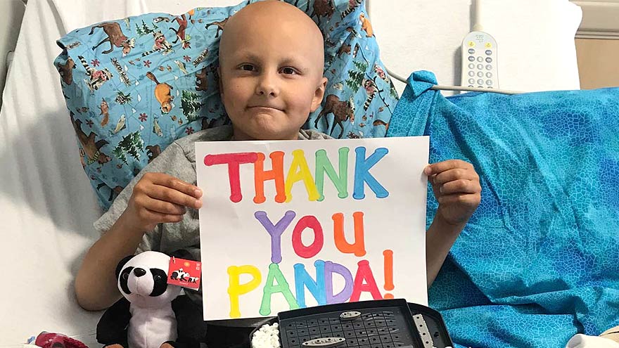 A child holding a poster saying Thank you Panda