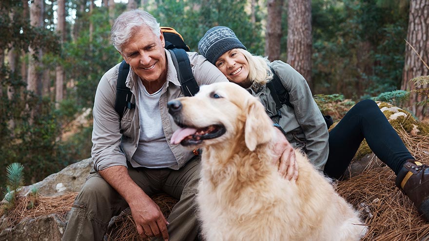 Senior couple hiking with dog