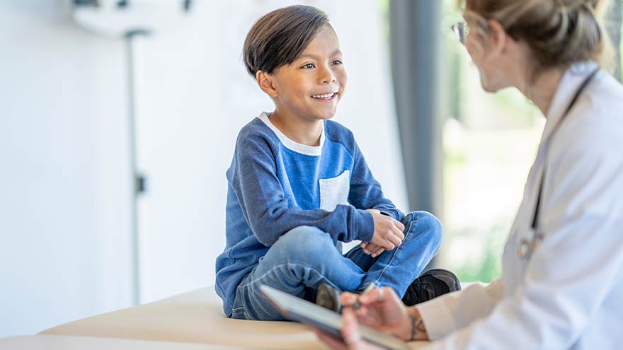 Child smiling and talking to their doctor